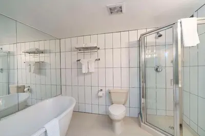 a bathroom with a tub and a toilet and a sink at Quality Inn Downtown Inner Harbour in Victoria