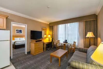 a hotel room with a bed and a living room at Quality Inn Downtown Inner Harbour in Victoria