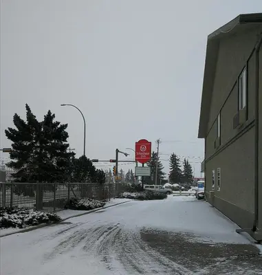 a snow covered street with a stop sign next to a building at Westlake Inn in Strathmore