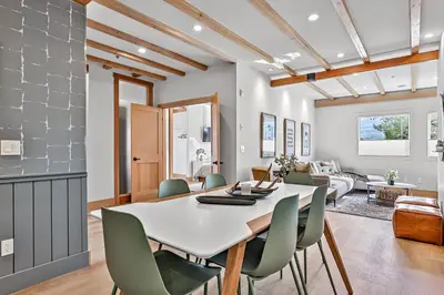 a dining room and living room with a table and chairs at Ravens Crest Lodge - Stunning Views Perfectly Located on Main Street in Canmore