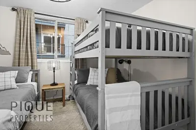 a bedroom with a bunk bed and a couch at Mystic Mountain Chalet, Heated Outdoor Pool & Hot Tub, Free Parking, Fast Wifi! in Canmore