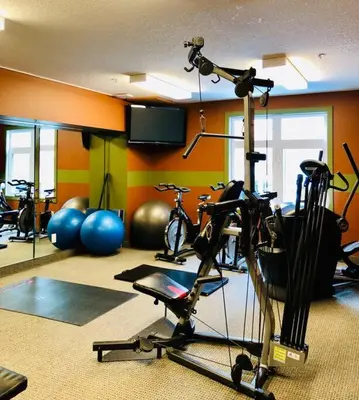 a gym with several bikes and a treadmill at Hotel Room in Windtower Lodge-121 in Canmore