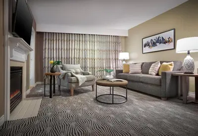 a living room with a couch and a fireplace at Sun Peaks Grand Hotel & Conference Centre in Sun Peaks