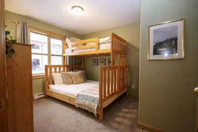 a bedroom with two bunk beds and a window at 2BR in Crystal Forest, Ski In, Ski Out, Fireplace, Private Hot Tub, Steps to the Village in Sun Peaks