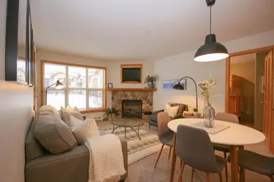 a living room with a couch and a table at 2BR in Crystal Forest, Ski In, Ski Out, Fireplace, Private Hot Tub, Steps to the Village in Sun Peaks