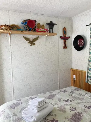 a bedroom with a bed and a shelf with towels at Jade City Motel in Jade City