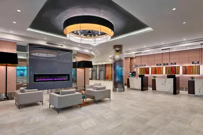 a lobby with couches chairs and a large screen at Delta Hotels by Marriott Edmonton Centre Suites in Edmonton