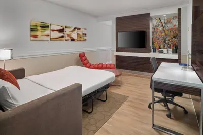 a room with a bed and a desk and a tv at Delta Hotels by Marriott Edmonton Centre Suites in Edmonton