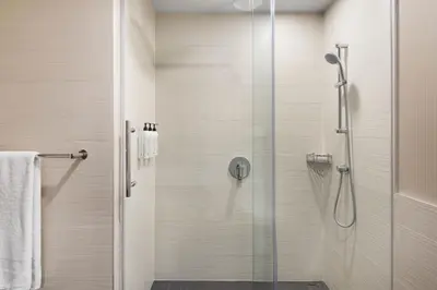a shower stall with a glass door in a bathroom at Delta Hotels by Marriott Edmonton Centre Suites in Edmonton