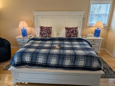 a bedroom with a bed with a blue and white plaid blanket at Salish B&B and Spa in West Kelowna
