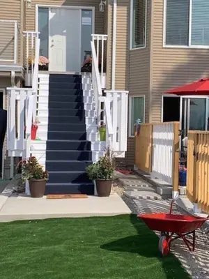 a red wheelbarrow in front of a house with stairs at Salish B&B and Spa in West Kelowna