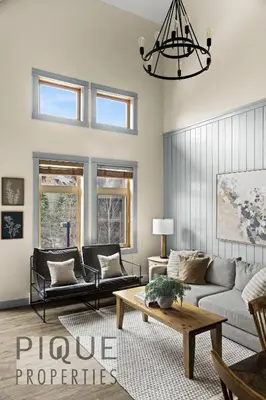 a living room with a couch and a table at Alpine Loft with Pool, Hot Tub & Mountain Views in Canmore