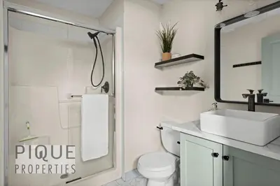 a bathroom with a sink and a toilet and a mirror at Alpine Loft with Pool, Hot Tub & Mountain Views in Canmore