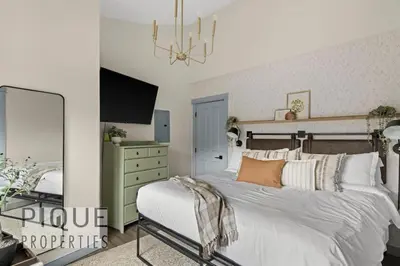a bedroom with a large bed and a mirror at Alpine Loft with Pool, Hot Tub & Mountain Views in Canmore
