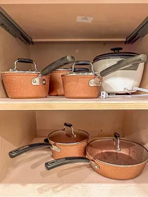 three pots and pans on a shelf in a kitchen at Skyline Getaway - Mountain Views - Pool - Hot Tub in Canmore