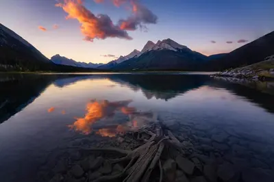 a view of a lake with a mountain in the background at Skyline Getaway - Mountain Views - Pool - Hot Tub in Canmore