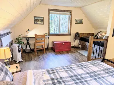 a bedroom with a bed and a desk in a room at 4 Mile Creek Cabin (Creekside) in Nelson