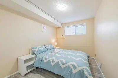 a bedroom with a bed with a blue and white bedspread at MT Pleasant NW 2 bedrooms 500 in Calgary