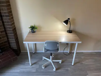 a wooden desk with a lamp and a chair at MT Pleasant NW 2 bedrooms 500 in Calgary