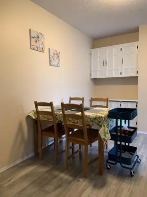 a dining room with a table and chairs and a kitchen at MT Pleasant NW 2 bedrooms 500 in Calgary