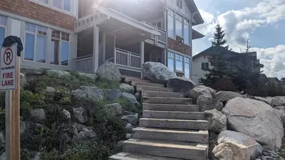 a house with stone stairs in front of a house at Settlers Crossing #29 By Bear Country in Sun Peaks