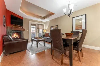 a dining room with a table and a fireplace at Solara Suite with Indoor Pool - Hot tub -Parking - GYM in Canmore