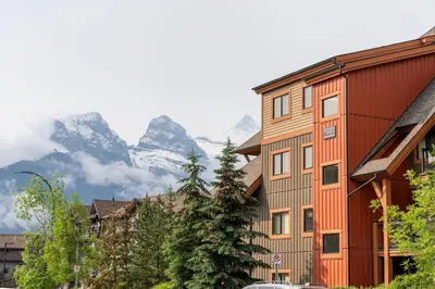 a group of buildings in front of a mountain at Solara Suite with Indoor Pool - Hot tub -Parking - GYM in Canmore