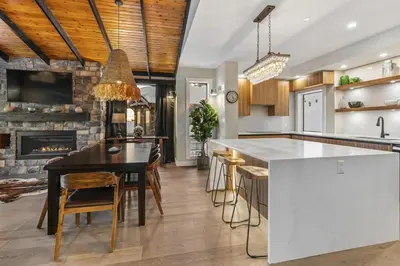 a kitchen with a dining table and a fireplace at Chalet Monashee - Brand New High-End Property with Amazing Views in Big White