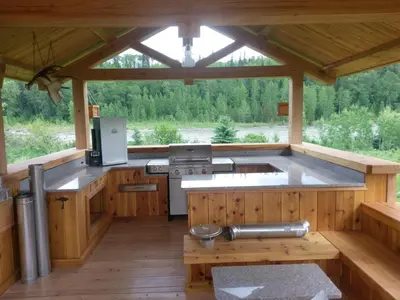 a large kitchen in a log cabin with a large window at LDR Lodge - Last Dollar Ranch in Smithers