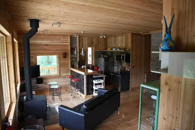 a living room with a couch and a stove at LDR Lodge - Last Dollar Ranch in Smithers