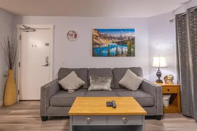 a living room with a couch and a table at 4 Bedrooms Suite Combo for Group of Families - Windtower Lodge in Canmore