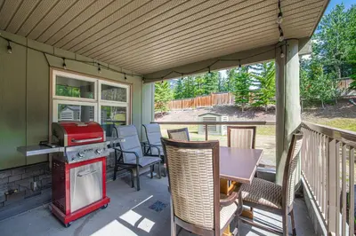 a screened in porch with a stove and a table at 4 Bedrooms Suite Combo for Group of Families - Windtower Lodge in Canmore