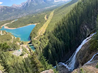 a view of a waterfall and a river in a forest at 4 Bedrooms Suite Combo for Group of Families - Windtower Lodge in Canmore