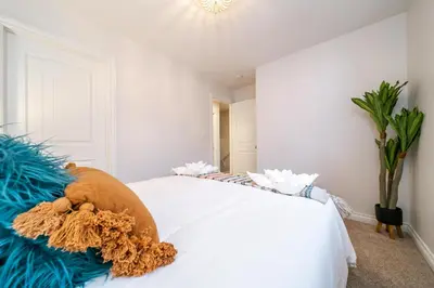 a bedroom with a white bed with a stuffed animal on it at Bali Style Home - King Bed - Fireplace - Jacuzzi - Fast Wi-Fi - Free Netflix & Garage Parking in Edmonton