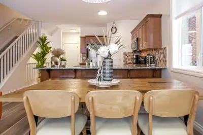 a dining room with a wooden table and chairs at Bali Style Home - King Bed - Fireplace - Jacuzzi - Fast Wi-Fi - Free Netflix & Garage Parking in Edmonton