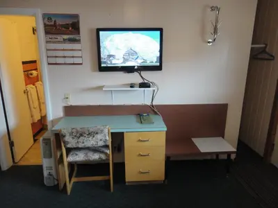a room with a desk and a tv on a wall at Airport Inn in Quesnel
