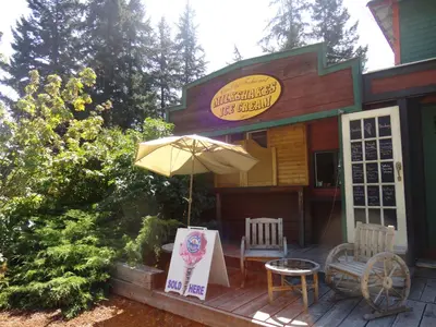 a restaurant with an umbrella and two chairs and a table at Old Towne Inne Chuckwagon Bar & Grill in Boston Bar