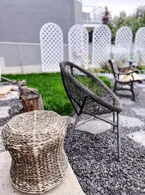 a wicker chair and a hat on a patio at Banff Garden Suite&2mins Bus station Close LRT& Free Parking in Calgary
