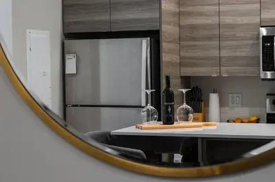 a mirror reflection of a kitchen with a table with wine bottles at Vita Resort Vernon on Lake Okanagan in Vernon