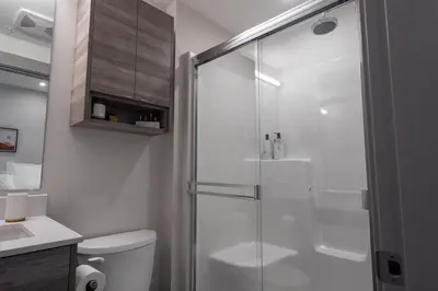 a bathroom with a shower with a toilet and a sink at Vita Resort Vernon on Lake Okanagan in Vernon