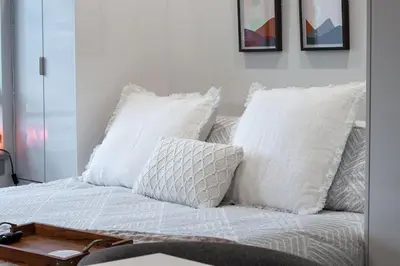 a white bed with white pillows on top of it at Vita Resort Vernon on Lake Okanagan in Vernon