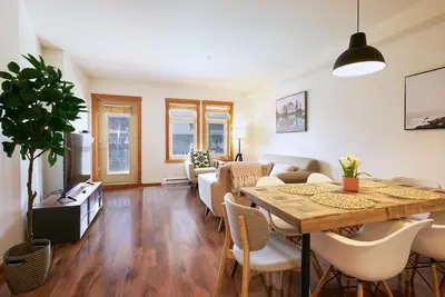 a living room with a table and a couch at Mtn View Escape with King Size Bed with Outdoor Pool - Banff Pass Included! in Canmore