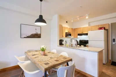 a kitchen and dining room with a table and chairs at Mtn View Escape with King Size Bed with Outdoor Pool - Banff Pass Included! in Canmore