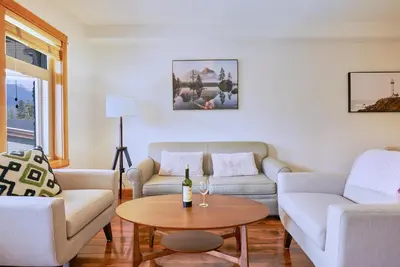 a living room with two couches and a table at Mtn View Escape with King Size Bed with Outdoor Pool - Banff Pass Included! in Canmore