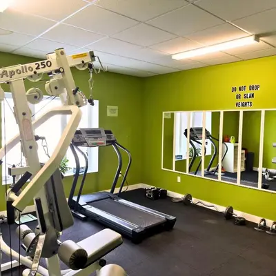 a room with a gym with a treadmill and a mirror at Carbon Valley Ranch in Grainger