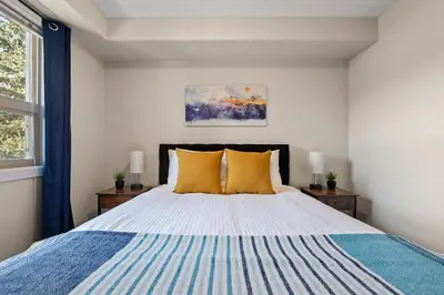 a bedroom with a large bed with yellow pillows at The Altitude Landing, Pool, Hot Tub, Pets in Invermere