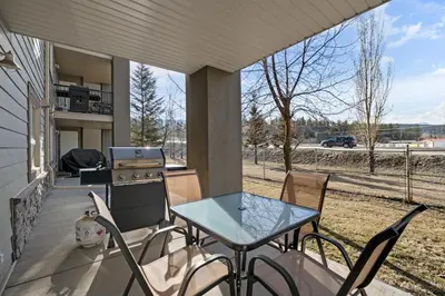 a patio with a table and chairs and a grill at The Altitude Landing, Pool, Hot Tub, Pets in Invermere