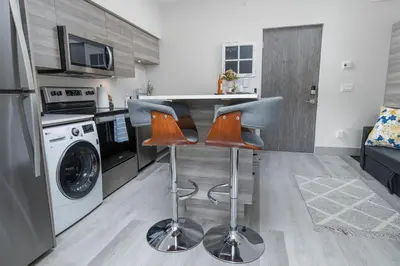 a kitchen with a counter and two bar stools at Top Floor on Okanagan Lake with AC & Heated Pool in Vernon