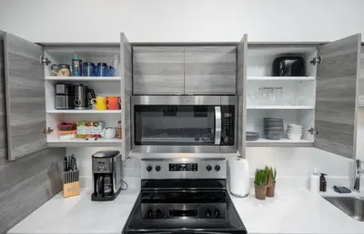 a kitchen with a microwave above a stove at Top Floor on Okanagan Lake with AC & Heated Pool in Vernon