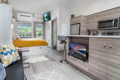 a bedroom with a bed and a fireplace in a room at Top Floor on Okanagan Lake with AC & Heated Pool in Vernon